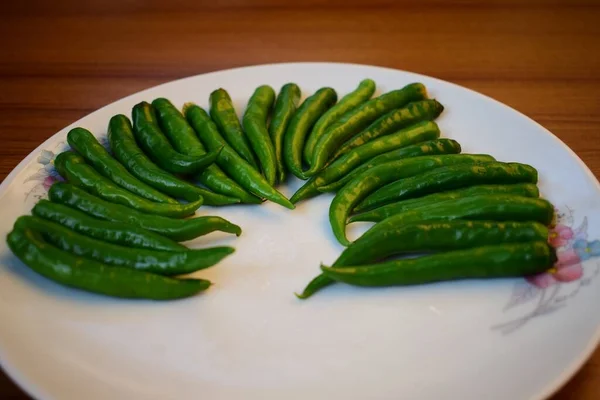 Ένα Κοντινό Πλάνο Πράσινες Πιπεριές Τσίλι Στοιβαγμένες Λευκό Πιάτο Ξύλινο — Φωτογραφία Αρχείου