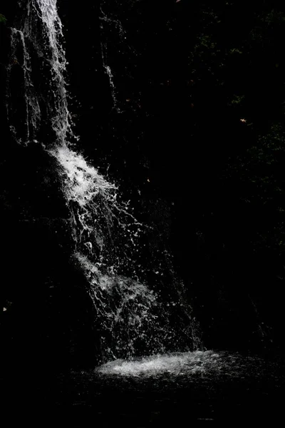 Захватывающий Каскад Водопада Над Камнями Черном Фоне — стоковое фото