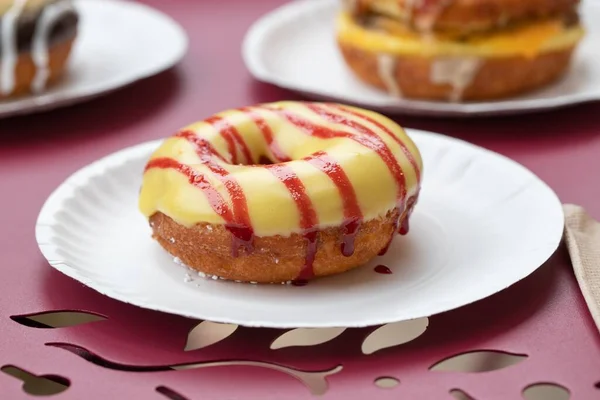 Ein Leckerer Donut Mit Gelber Und Roter Sahne Einem Pappteller — Stockfoto