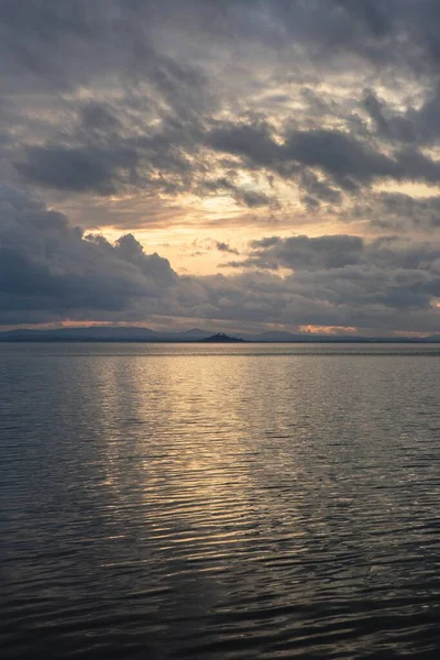 美丽的大海映照着夕阳西下的灯光和多云的天空 — 图库照片