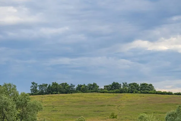 Piękny Wiejski Krajobraz Wzgórzem Zieloną Łąką Błękitnym Wieczornym Niebem — Zdjęcie stockowe
