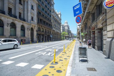 BARCELONA, SPAIN - Jul 06, 2020: covid measures in the streets , expansion of space for pedestrian with espacial lane and yellow paint and posts clipart