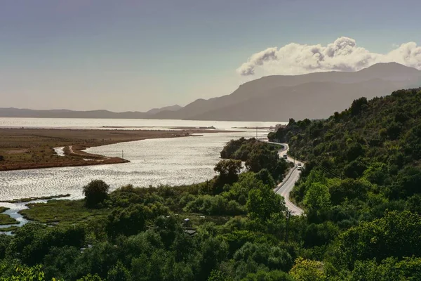 美丽的风景 在绿树成荫的山坡和河流上有一条路 — 图库照片