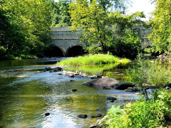 暖かい夏の日にメリーランド州のガンパウダー公園の小さな川の上に古いアーチ橋 — ストック写真