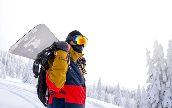 Een Snowboarder Beschermende Bril Houdt Zijn Snowboard Zijn Rug Met — Stockfoto