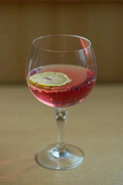 甜甜的果汁在玻璃和切片柠檬在木制表面上 — 图库照片