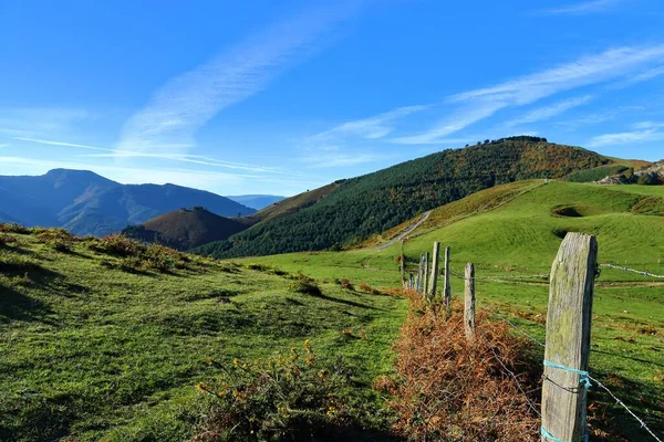 Uma Colina Verde Com Vista Para Montanhas Sob Céu Azul — Fotografia de Stock