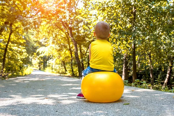 Back View Male Child Yellow Bouncy Ball Park Sunny Day — Stock Photo, Image