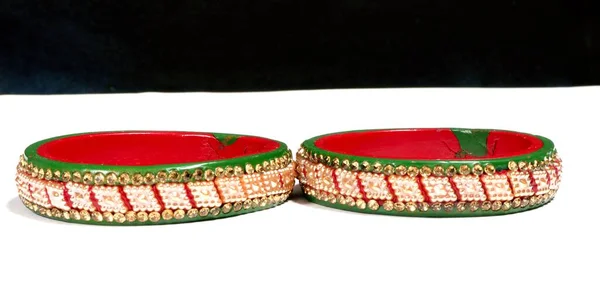 白い表面に小さな石で飾られた2つの赤と緑のブレスレットの閉鎖 — ストック写真