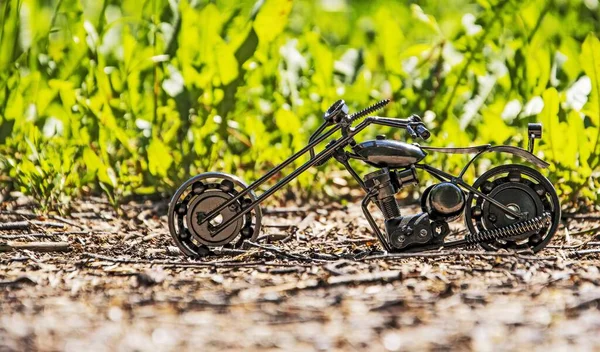 道路チョッパーのおもちゃの手作りの金属モデルは 抽象的な緑の背景に舗装に立っています — ストック写真