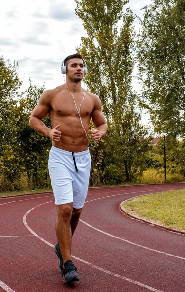 Jovem Caucasiano Usando Fones Ouvido Correndo Durante Seu Treino — Fotografia de Stock