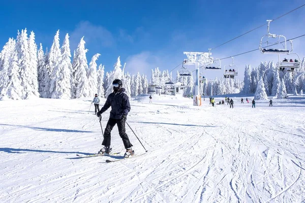 一个滑雪者带着滑雪板滑下山 — 图库照片