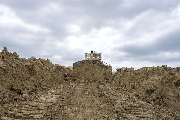 Una Excavadora Moviendo Tierra Rocas Sitio Construcción Contra Cielo Nublado —  Fotos de Stock