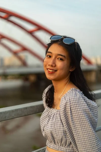 Köprüde Güneş Gözlüklü Gülümseyen Asyalı Bir Kadının Dikey Çekimi — Stok fotoğraf
