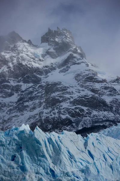 Tiro Vertical Ângulo Baixo Montanha Coberta Neve Contra Céu Nublado — Fotografia de Stock