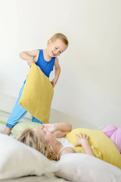 Duas Crianças Caucasianas Brincando Juntas Com Travesseiros Cama — Fotografia de Stock