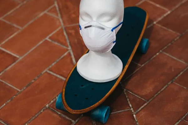 Een Witte Mannequin Hoofd Met Een Medisch Gezichtsmasker Een Skateboard — Stockfoto