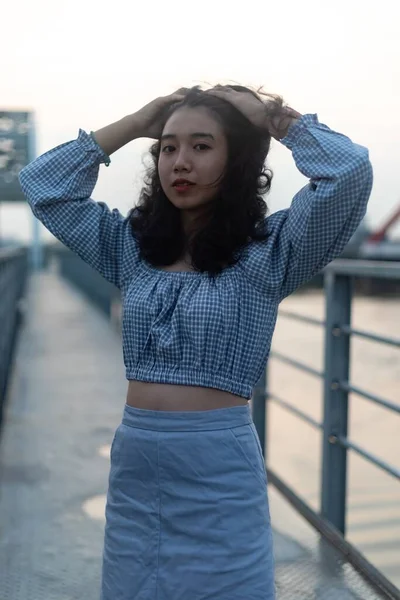 橋の上に立つ魅力的なアジアの女性の垂直ショット — ストック写真