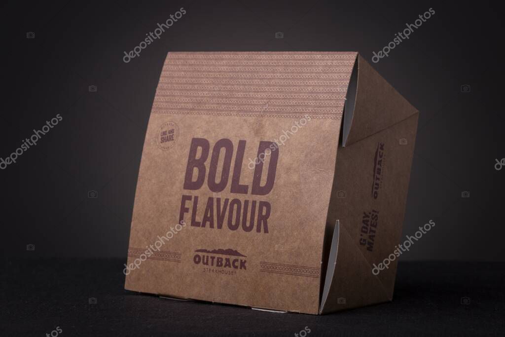 RIO DE JANEIRO, BRAZIL - Jul 01, 2020: Two meal delivery cardboard boxes of Outback steakhouse restaurant on top of each other with written 'Bold flavour'. Studio low key food still life.