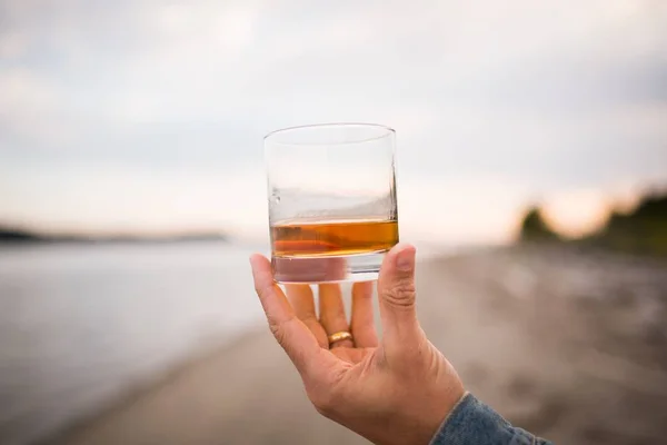 Closeup Shot Male Hand Holding Glass Whiskey Blurred Background — Stock Photo, Image