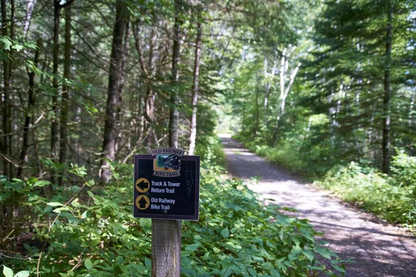 A closeup shot of a wooden signpost of the Old Railway Bike Trail in Ontario, Canada