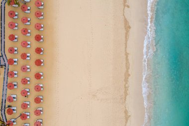An aerial symmetric shot of beach umbrella rows at the Nusa Dua beach in Bali, Indonesia clipart