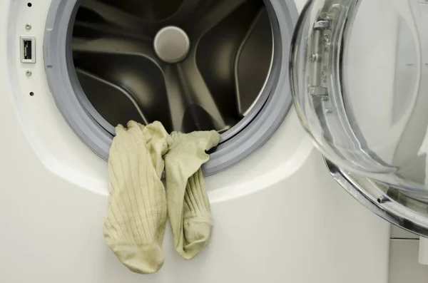 A closeup shot of the dirty laundry hanging from the washing machine