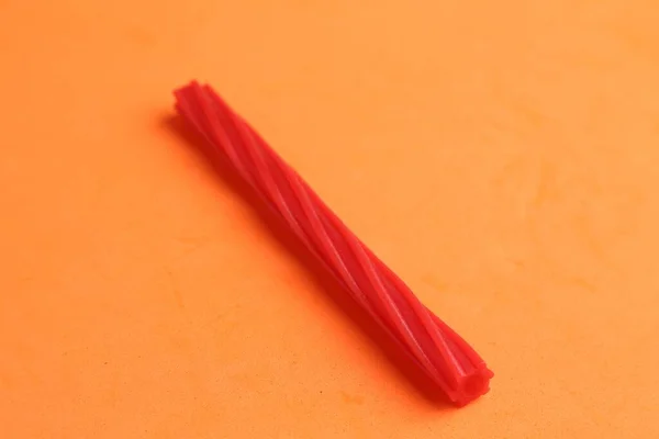 Egy Narancssárga Alapon Izolált Piros Medvecukor Pálcika Nagylátószögű Képe — Stock Fotó