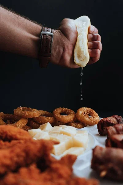 目玉焼きにレモンを絞る男の垂直ショットや他の食品 — ストック写真