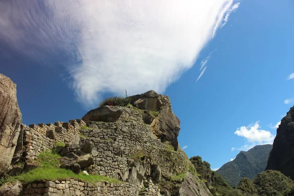 太陽の光の下でペルーのアンデス山脈に位置するマチュピチュの歴史的な場所の低角度ショット — ストック写真