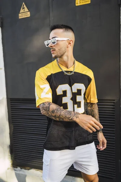 Vertikální Záběr Mladého Vytetovaného Evropského Bočního Muže Žlutočerném Sportovním Oblečení — Stock fotografie