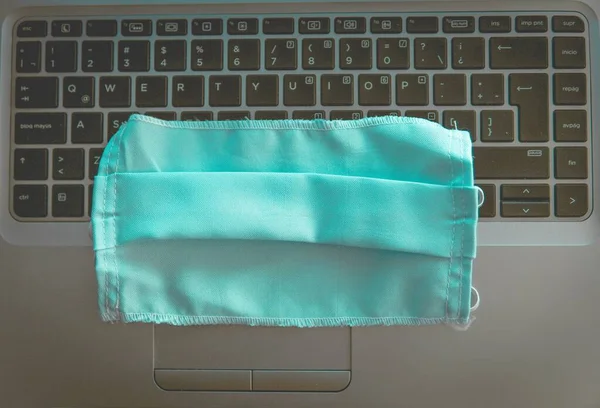 黒いキーボードの青い医療用マスクのクローズアップショット — ストック写真