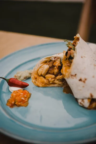 Eine Vertikale Selektive Fokusaufnahme Von Schmackhaftem Burrito Auf Blauem Teller — Stockfoto