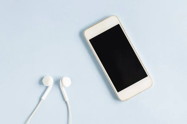 Nahaufnahme Eines Weißen Smartphones Und Kopfhörers Auf Hellblauem Hintergrund — Stockfoto