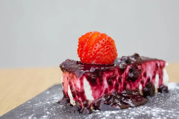 黒スグリソースのチーズケーキとイチゴをトッピングしたクローズアップショット — ストック写真