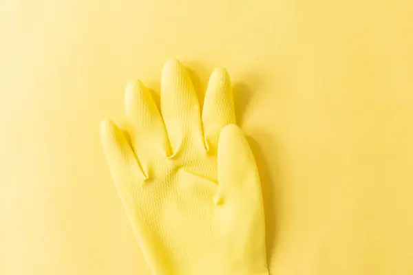 Nahaufnahme Eines Gelben Plastikhandschuhs Auf Gelbem Hintergrund — Stockfoto
