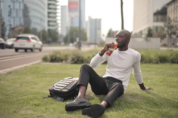 Een Stijlvolle Afrikaanse Man Met Een Bril Het Gras Drinken — Stockfoto