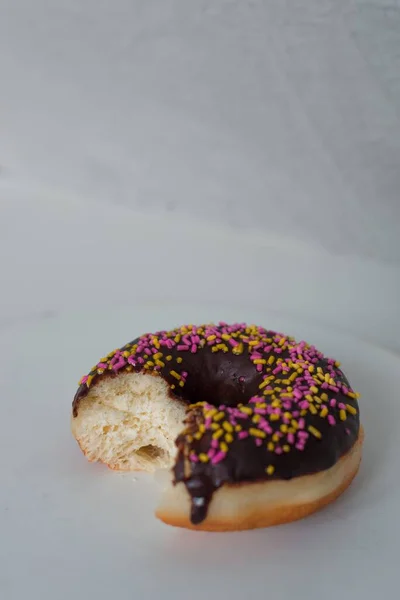Tiro Close Vertical Donut Mordido Com Creme Chocolate Polvilhas Coloridas — Fotografia de Stock