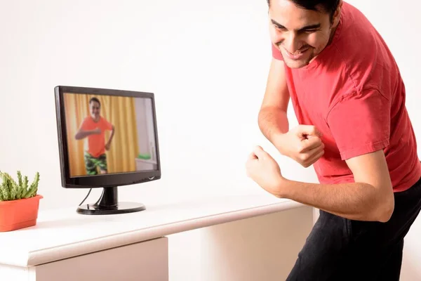 집에서의 새로운 티셔츠를 춤추는 사회적 남자가 노트북으로 온라인 비디오를 있어요 — 스톡 사진