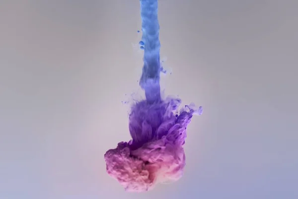 Primer Plano Explosión Tinta Color Arco Iris Sobre Fondo Púrpura — Foto de Stock