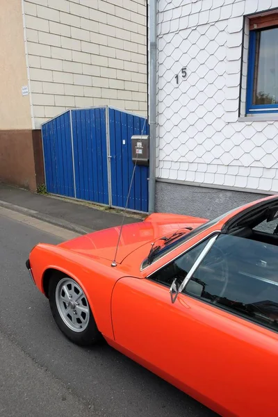 1970年代のドイツのミッドエンジンスポーツ車で オレンジレッドの折り畳み式ヘッドライトが付いています — ストック写真