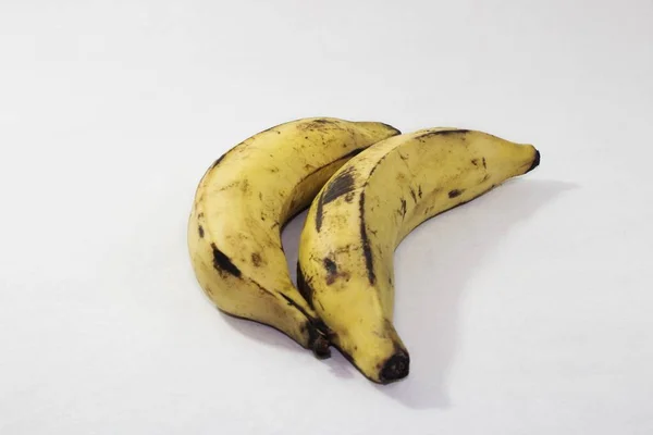 Два Банана Черными Отметинами Белом Фоне — стоковое фото