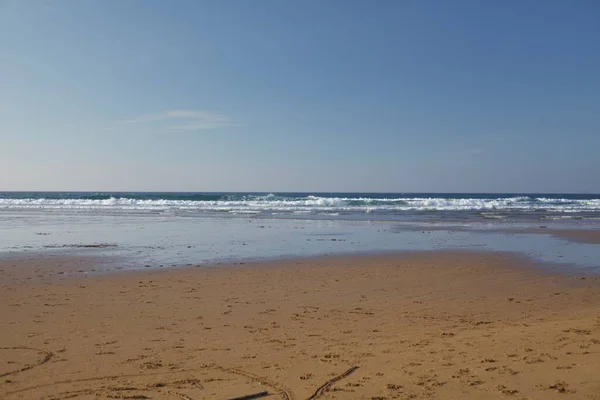 海岸線に泡の波がクラッシュし 明確な地平線と砂浜の牧歌的な景色 壁紙に最適です — ストック写真