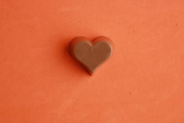 Turuncu Arka Planda Kalp Şeklinde Çikolatanın Yakın Plan Çekimi — Stok fotoğraf
