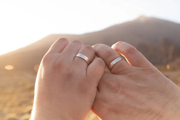 晴れた日に銀の結婚指輪を持つ結婚式のカップルの手のクローズアップショット — ストック写真