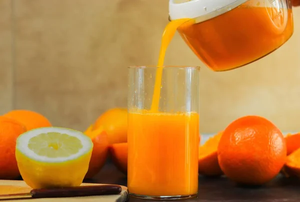 Zbliżenie Osoby Wylewającej Świeży Sok Pomarańczowy Szklanki Stole Pomarańczami Cytrynami — Zdjęcie stockowe