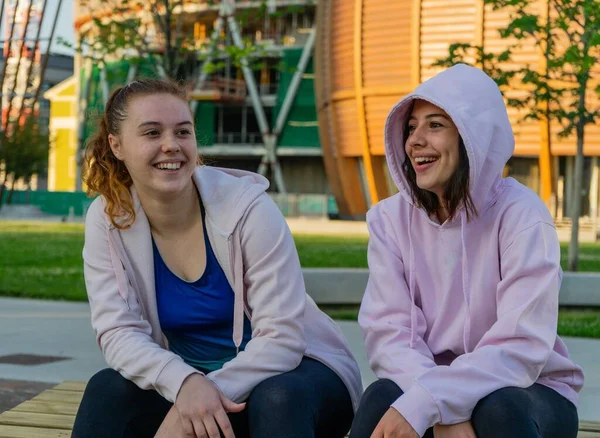 Duas Garotas Caucasianas Sentadas Pedra Conversando Sorrindo Alegremente Conceito Amizade — Fotografia de Stock