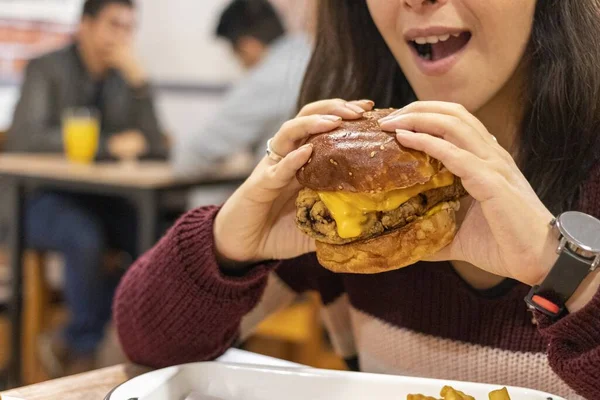 Uma Foto Close Uma Mulher Comendo Hambúrguer Restaurante — Fotografia de Stock