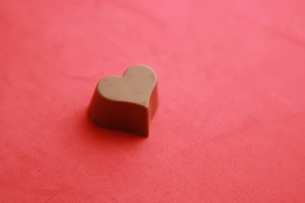 Kırmızı Arka Planda Kalp Şeklinde Çikolatalı Şekerin Yakın Plan Çekimi — Stok fotoğraf