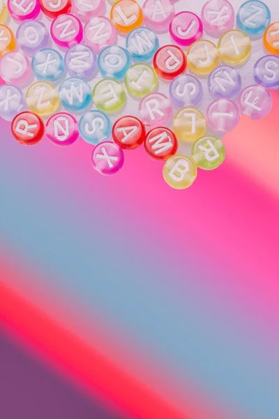 Eine Vertikale Aufnahme Von Buchstaben Perlen Spielzeug Auf Buntem Hintergrund — Stockfoto